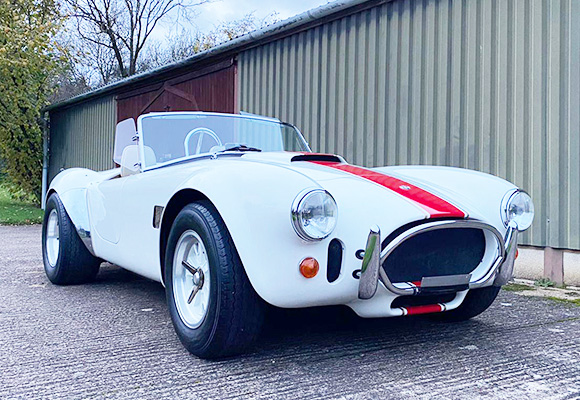 classic white sports car with red accents parked in front of a building showing the sleek design and vintage appeal of this iconic automobile 2 of a kind performance